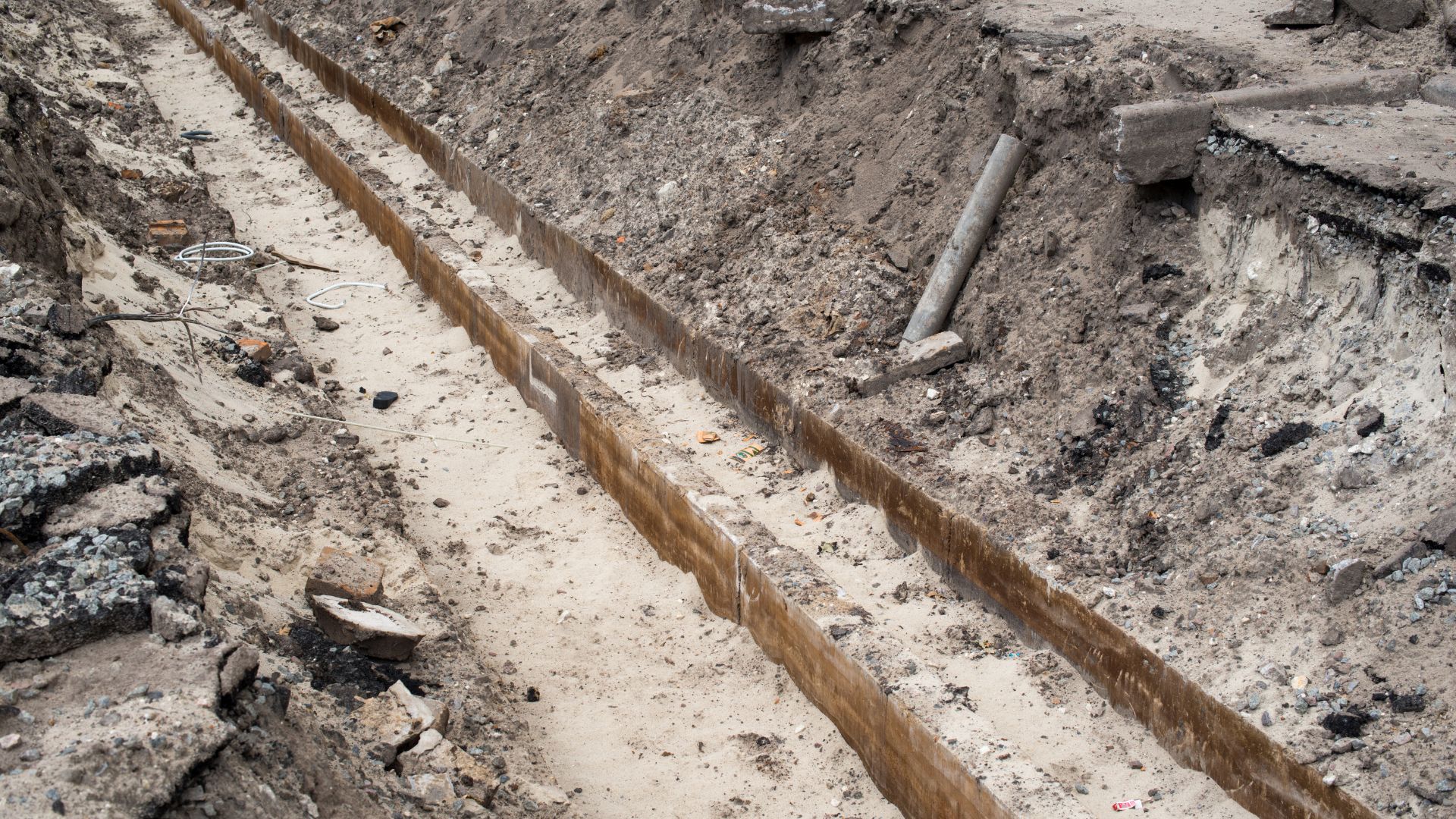 Construction site with deep trenches and exposed soil for underground utilities